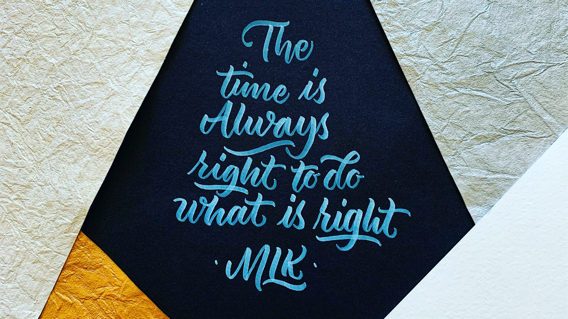 "The time is Always right to do what is right" MLK. Martin Luther King Jr. quote painted with light blue paint on a navy blue wall. Textured background.