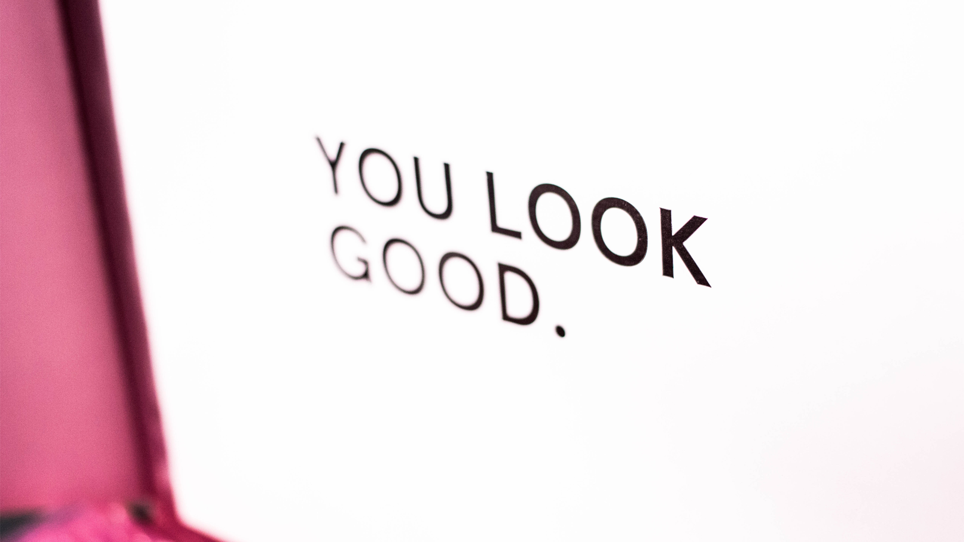 An angled photo of text that says You Look Good in all caps with a white background and black text.
