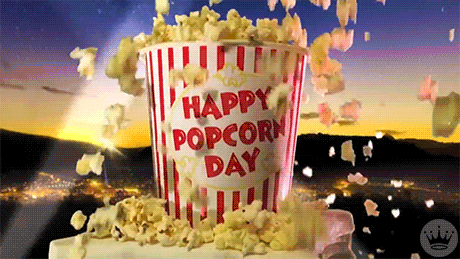 Animated bucket of popcorn with popcorn flying out of it that says Happy Popcorn Day on the outside of the bucket.