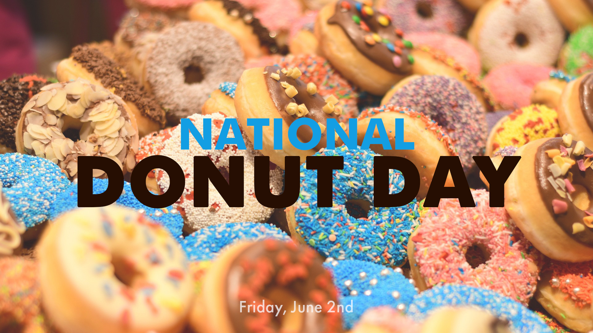 Photo of a bunch of frosted donuts are stacked on one another with sprinkles in the middle of the graphic it reads National Donut Day Friday, June 2nd