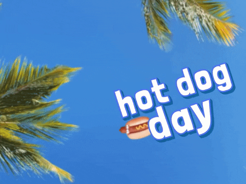 Animated photo of what it appears to be looking directly up into a blue sky with green palm trees around. Animated hot dog with mustard and a face comes twirling in on the left side of the graphic and white text with a blue outline reads hot dog day.
