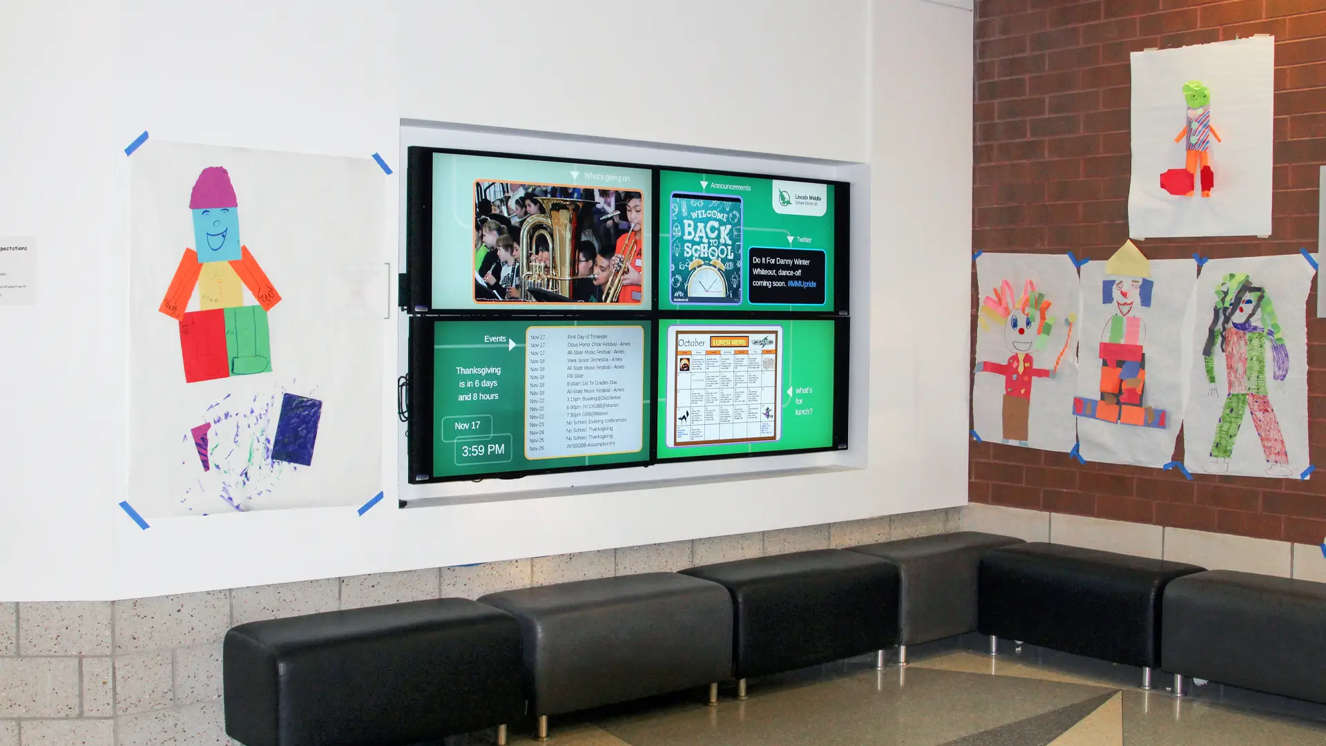 A 2x2 Video wall using 42" screens are built into a lobby corner wall above the seating area with student artwork on the walls. Powered by Arreya School Digital Signage this display is showcasing schools events, monthly menu, twitter news and annnouncements.