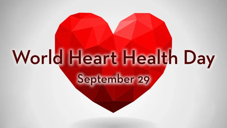 A white background with a black vignette. Floating in the center is a red, faceted heart. The words 'World Heart Health Day September 29' sit over the center and cross the the center of the heart. The words are dark brown, red in color, and use a bold, sans font with a white transparent drop shadow.