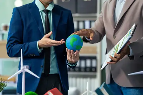 Hands holding a small world globe discussing corporate impact and responsibiltiy