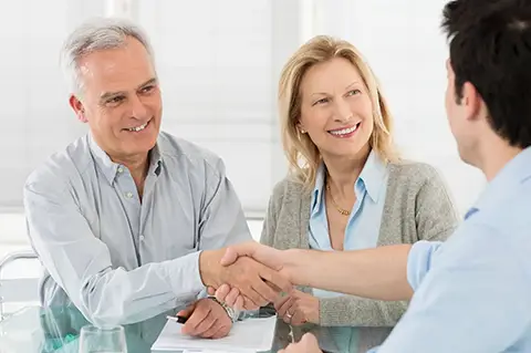 Banking clients shaking hands after expanding their portfolio