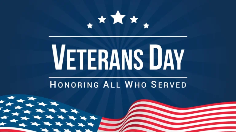 A dark blue radial shaped background with a clip art image of the American flag waving against the bottom edge. Centered above reads ‘Veterans Day’ in large, bold letters and ‘Honoring All Who Served’ in small, thin letters below. ‘Veterans Day’ has a thin horizontal line above and below it. Arched at the very top of the image are five white stars. An all-caps, sans font was used for all the words.