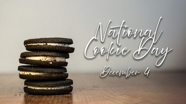 A photo of four Oreo cookies stacked on top of each other sits on a wooden table, and on the left side of the image. To the right reads ‘National Cookie Day December 4’ in thin white cursive letters with a drop shadow.