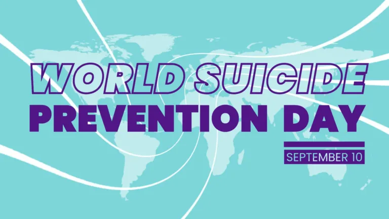A transparent white world map fills the graphic background against a light teal-blue ocean. Six curved white lines come from the edges and meet in the center. The graphic’s center is filled with words. First is ‘WORLD SUICUDE’ in bold, transparent, sans bubble letters with a dark purple outline. Then the words ‘PREVENTION DAY’ use the same bold sans font and size, but are filled in with the dark purple color. Below the word Day is a thick horizontal line, a space, and then a thicker purple rectangle. Inside the rectangle is the date September 10 in semi-bold sans letters and the same color of the map’s oceans.