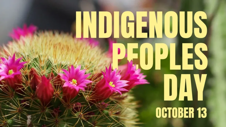 A close-up photo of the top of a rounded cactus with bright, hot pink flowers around its top. The background is entirely blurred, but appears to be more plants. Stacked, right aligned in the right side are the words, ‘INDIGENOUS PEOPLES DAY’ in large butter yellow sans letters. The word ‘peoples’ is slightly behind the cactus. Below the word ‘day’ in the same font, but much smaller in size, is the date October 13.