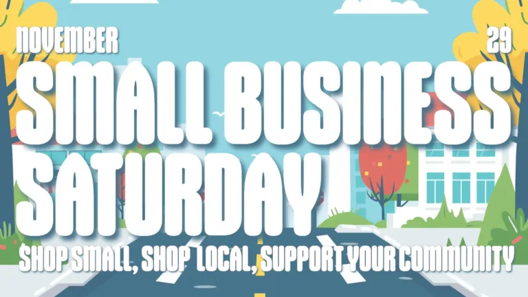 A digital drawing of a street lined with white buildings and yellow fall trees against a bright blue sky fill the graphic. Overlaid on top are large white, bold, round, sans words. The middle is covered in ‘small business’ ‘saturday’ stacked and left aligned. Adobe the s and m in small is the month NOVEMBER. Above the last s in business is the date 29. Along the bottom edge reads, “SHOP SMALL, SHOP LOCAL, SUPPORT YOUR COMMUNITY.”