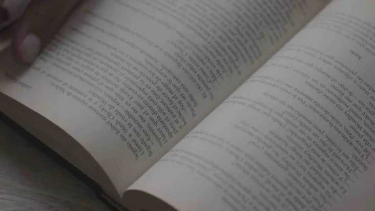 A video of an open book filled with small black text. Occasionally a hand turns the pages.