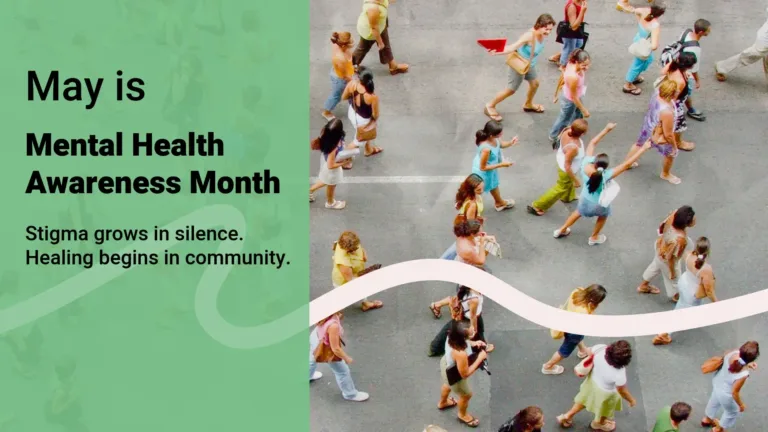 A birds-eye view photo of a crowd of people walking together on a asphalt street. The left side has been covered up by a transparent sage green rectangle. Inside the rectangle reads, "May is, Mental Health Awareness Month, Stigma grows in silence. Healing begins in community." A black sans font was used. Mental health awareness month is bolded. A horizontal. off-white, wavy line crosses the graphic near the bottom half. It is over the photo, but under the rectangle and words.